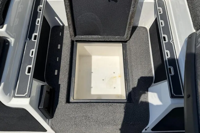 Slide: The Image of 2014 Skeeter FX 20 boat storage compartment with open lid, showing interior space. - 9