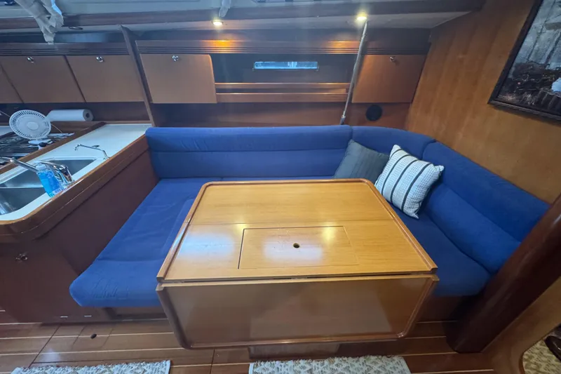 Slide: The Image of Interior of 2004 Dufour 40 Performance yacht with blue seating and wooden table. - 15
