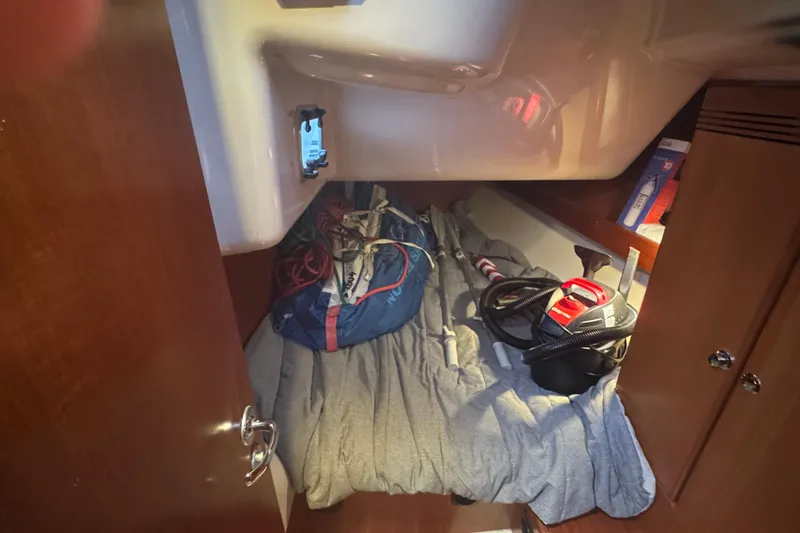 Slide: The Image of Cozy cabin storage in 2004 Dufour 40 Performance sailboat, featuring equipment and supplies. - 16