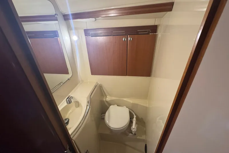 Slide: The Image of Bathroom interior of 2004 Dufour 40 Performance yacht with sink, toilet, and wooden cabinets. - 24