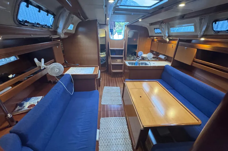 Slide: The Image of Interior of 2004 Dufour 40 Performance yacht with blue seating and wooden finishes. - 26