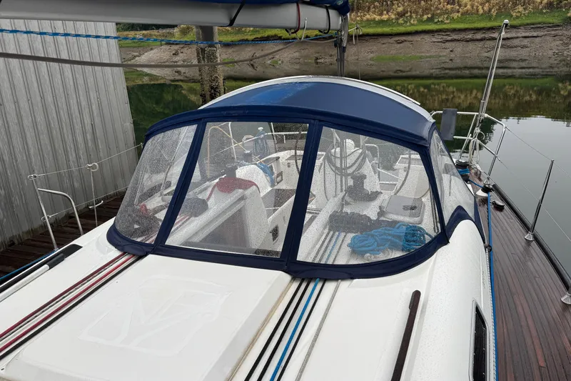 Slide: The Image of Dufour 40 Performance 2004 sailboat with blue canopy docked by calm waters. - 7