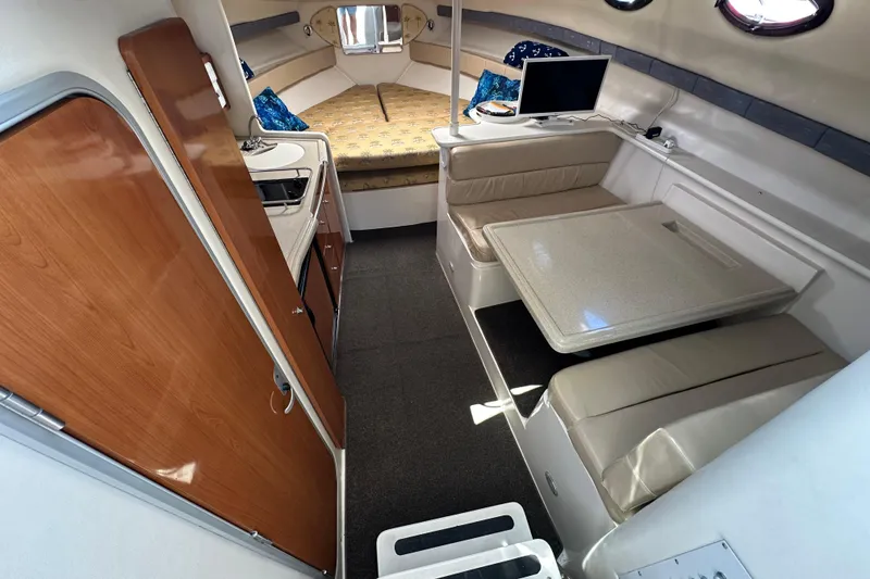 Slide: The Image of 2003 Wellcraft 330 Coastal interior with kitchenette, seating area, and cozy sleeping space. - 11