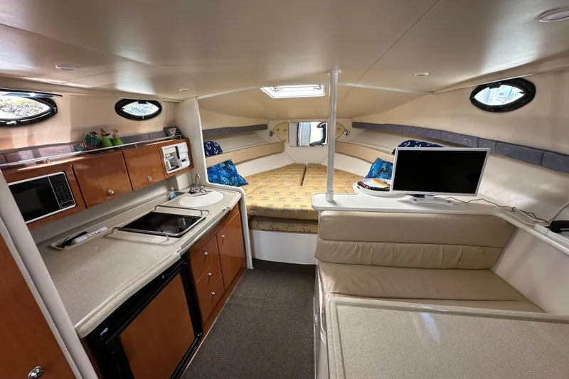 Slide: The Image of 2003 Wellcraft 330 Coastal interior with kitchenette, seating, and sleeping area. - 12