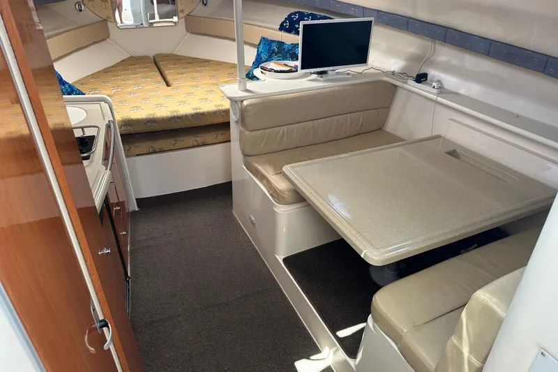 Slide: The Image of 2003 Wellcraft 330 Coastal cabin interior with dining area and bed. - 13