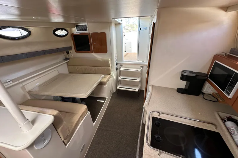Slide: The Image of 2003 Wellcraft 330 Coastal interior with kitchenette, dining area, and modern amenities. - 14