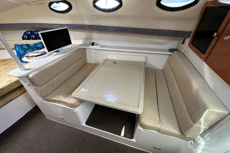 Slide: The Image of 2003 Wellcraft 330 Coastal cabin interior with beige seating and table. - 16