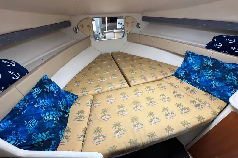 Slide: The Image of 2003 Wellcraft 330 Coastal cabin interior with tropical-themed bedding and nautical pillows. - 18