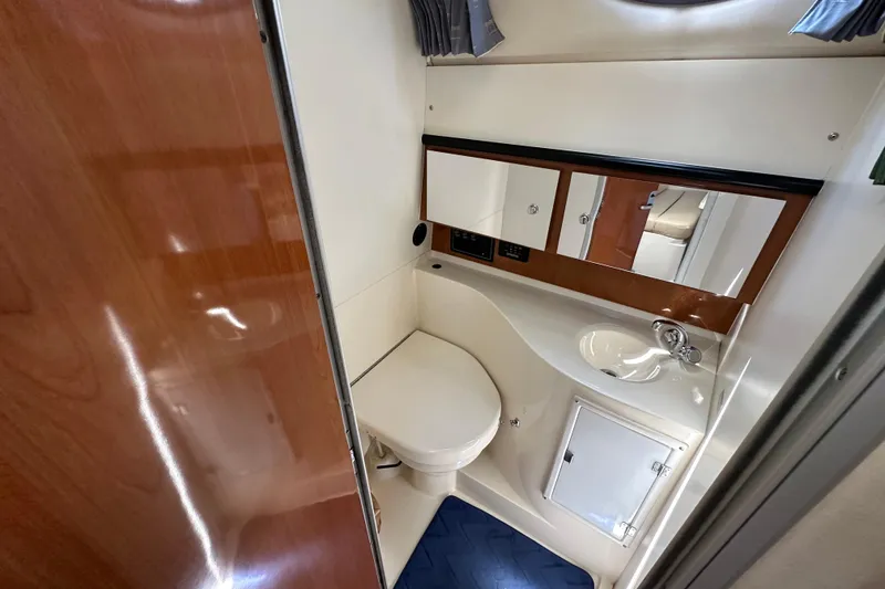 Slide: The Image of 2003 Wellcraft 330 Coastal boat bathroom with sink, toilet, and mirrored cabinet. - 19