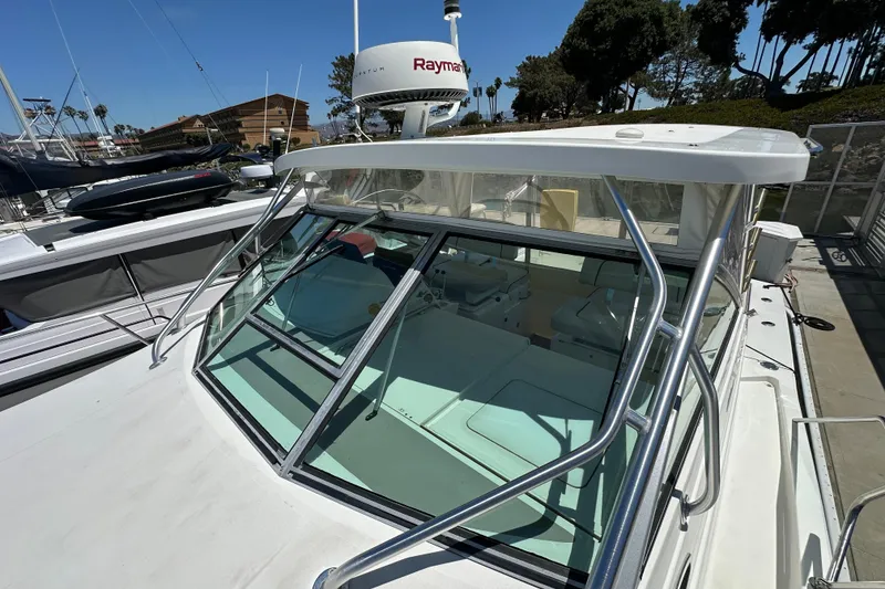 Slide: The Image of 2003 Wellcraft 330 Coastal boat docked, featuring windshield and radar equipment. - 2