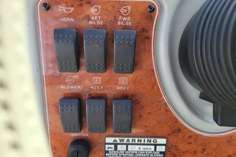 Slide: The Image of Control panel of a 2007 Bayliner 245 Cruiser with switches and warning label. - 13