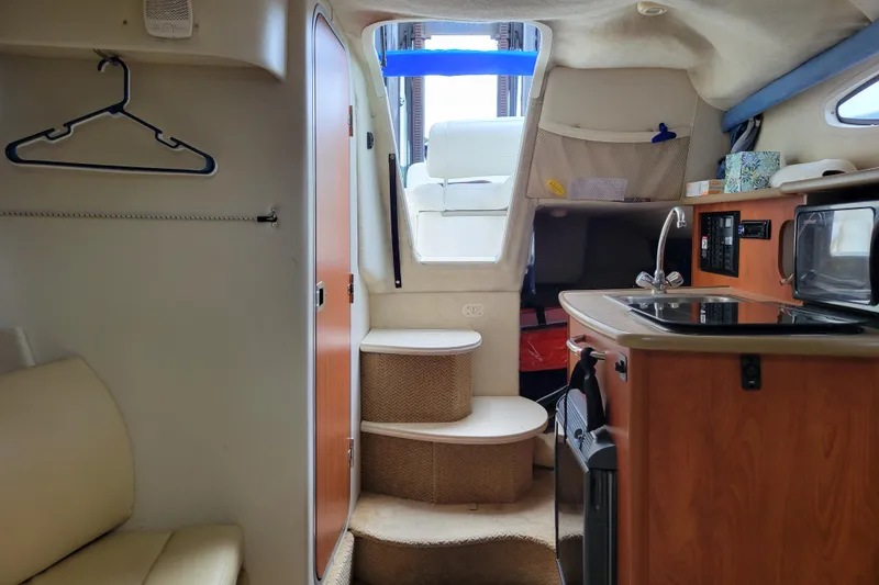 Slide: The Image of Interior of a 2007 Bayliner 245 Cruiser with kitchenette and seating area. - 25