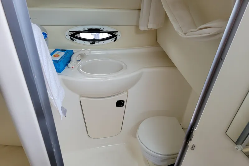 Slide: The Image of 2007 Bayliner 245 Cruiser bathroom with sink, toilet, and small window. - 26