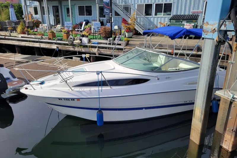 Slide: The Image of 2007 Bayliner 245 Cruiser docked at a marina with blue canopy. - 4