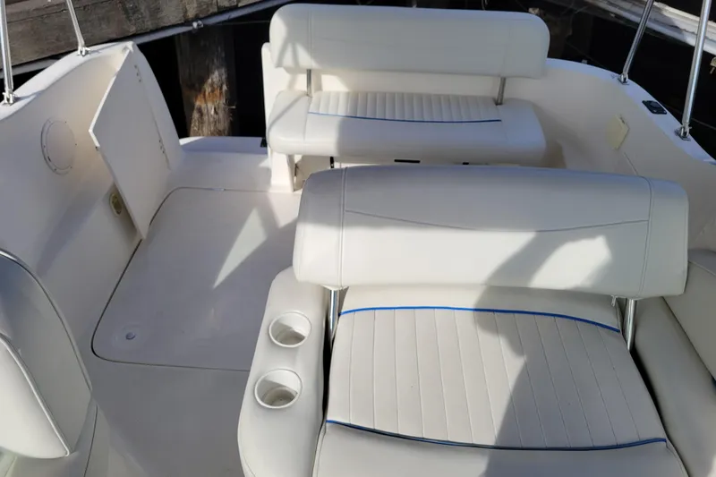 Slide: The Image of 2007 Bayliner 245 Cruiser interior with white seating and cup holders. - 6