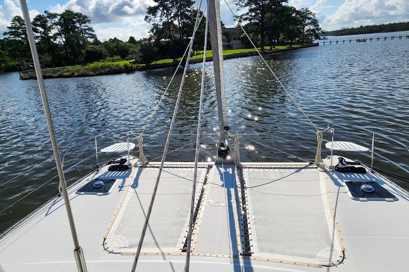Slide: The Image of 2007 Antares Catamarans PDQ 44i sailing on a serene lake with lush greenery. - 11