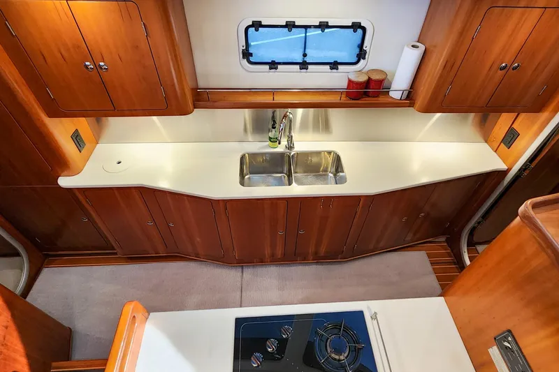 Slide: The Image of Luxurious 2007 Antares Catamarans PDQ 44i kitchen with wooden cabinets and dual sink. - 33