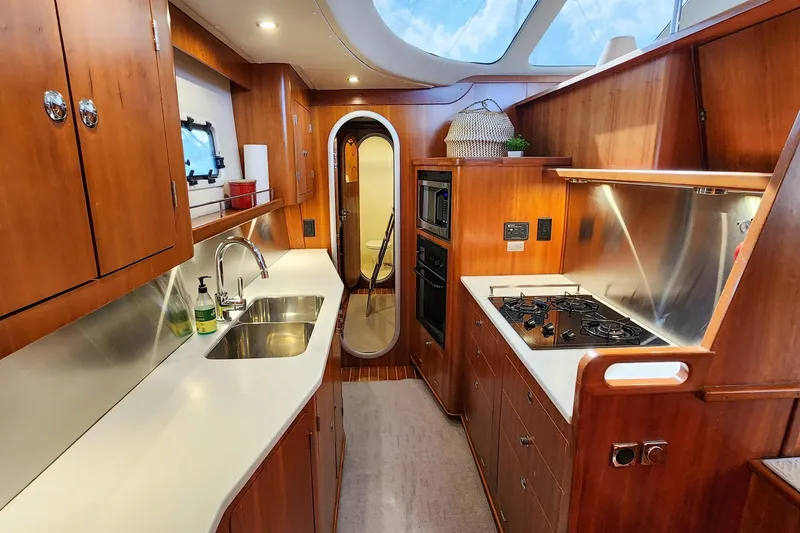 Slide: The Image of Luxurious 2007 Antares Catamarans PDQ 44i kitchen with wood cabinetry and modern appliances. - 36