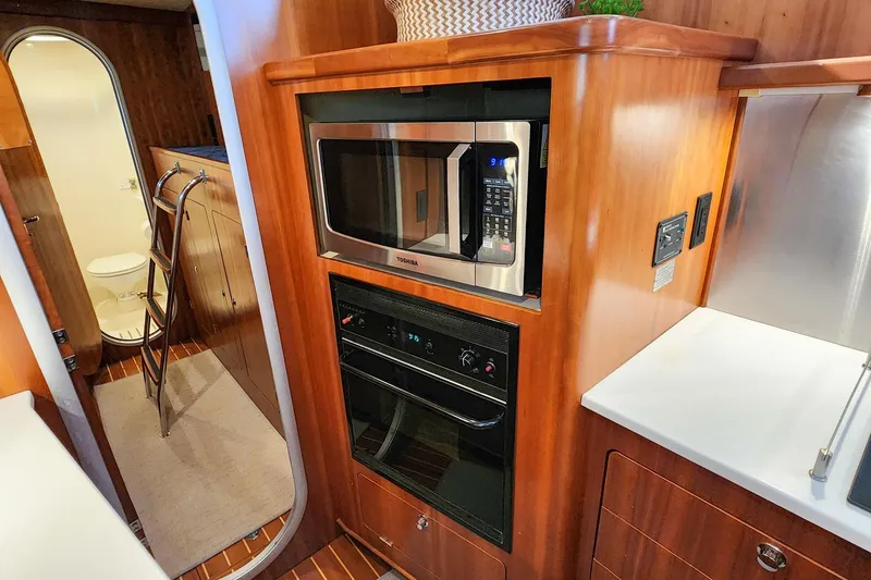 Slide: The Image of 2007 Antares Catamarans PDQ 44i galley with microwave, oven, and wooden cabinetry. - 38