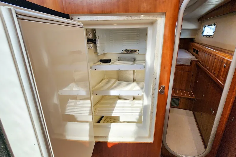 Slide: The Image of Empty refrigerator inside 2007 Antares Catamarans PDQ 44i, with wooden interior details. - 39