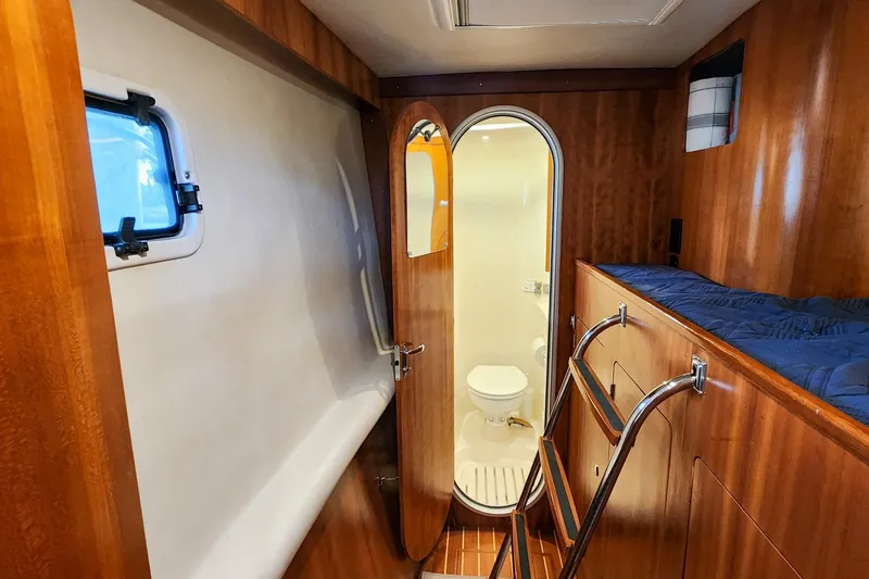 Slide: The Image of Interior of 2007 Antares Catamarans PDQ 44i, featuring a compact bathroom and wooden cabinetry. - 41