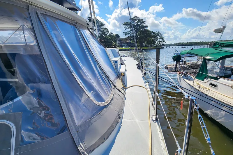 Slide: The Image of 2007 Antares Catamarans PDQ 44i docked, featuring sleek design and clear canopy under blue skies. - 6