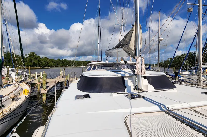 Slide: The Image of 2007 Antares Catamarans PDQ 44i docked at a marina under a blue sky. - 8