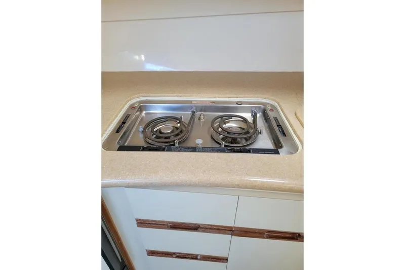 Slide: The Image of 1996 Phoenix 34 Tournament boat kitchen with dual-burner stove, beige countertop. - 11