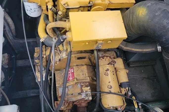 Slide: The Image of Engine compartment of a 1996 Phoenix 34 Tournament boat, featuring yellow machinery and hoses. - 12