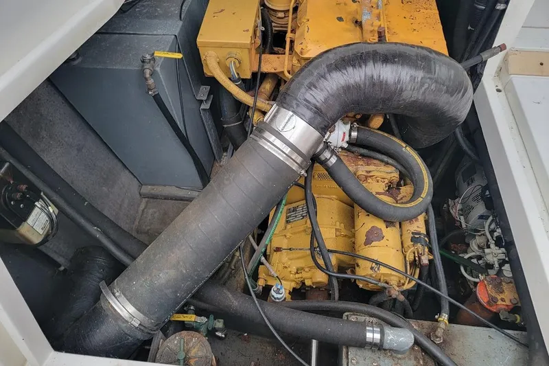 Slide: The Image of Engine compartment of a 1996 Phoenix 34 Tournament boat, featuring hoses and machinery. - 13