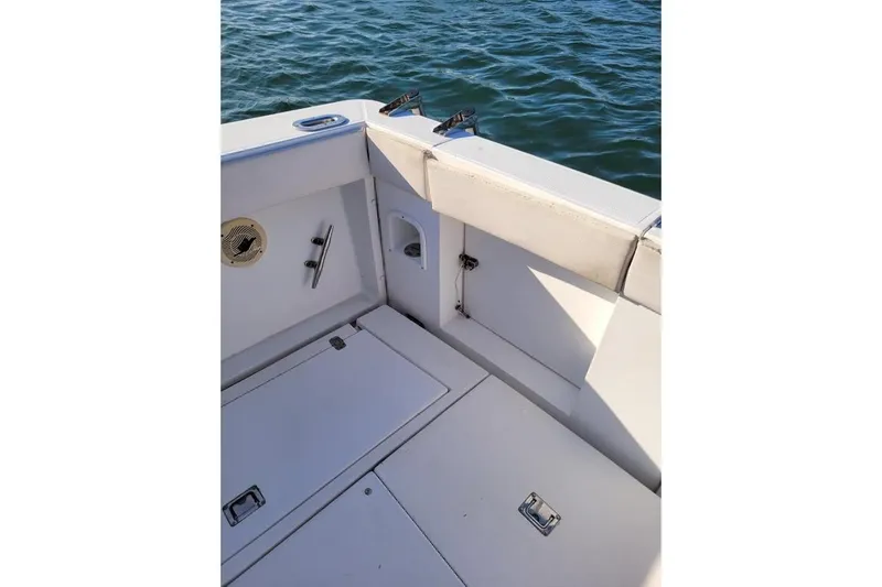 Slide: The Image of 1996 Phoenix 34 Tournament boat deck with storage compartments, near calm water. - 18