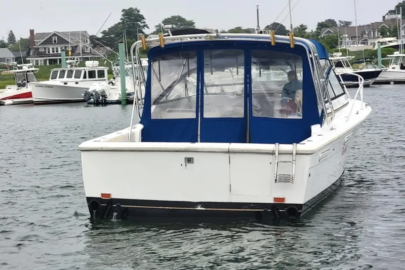 Slide: The Image of 1996 Phoenix 34 Tournament boat docked in a marina, featuring a blue canopy. - 2