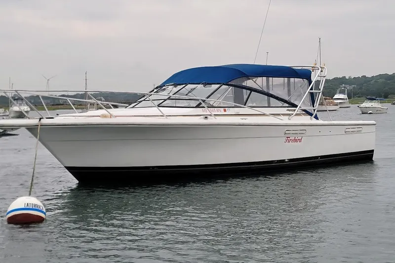 Slide: The Image of 1996 Phoenix 34 Tournament boat with blue canopy, moored in calm waters. - 26