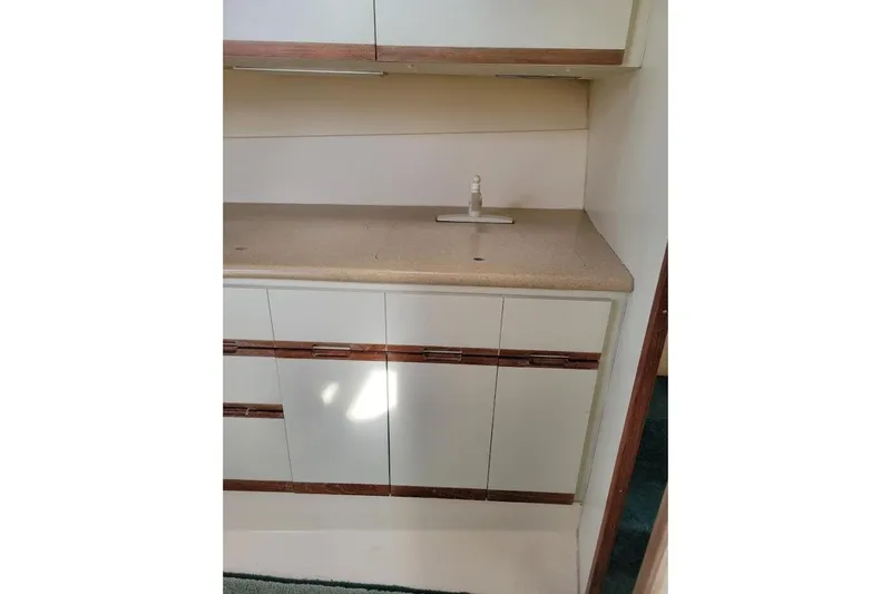 Slide: The Image of 1996 Phoenix 34 Tournament boat interior with beige countertop and white cabinets. - 27