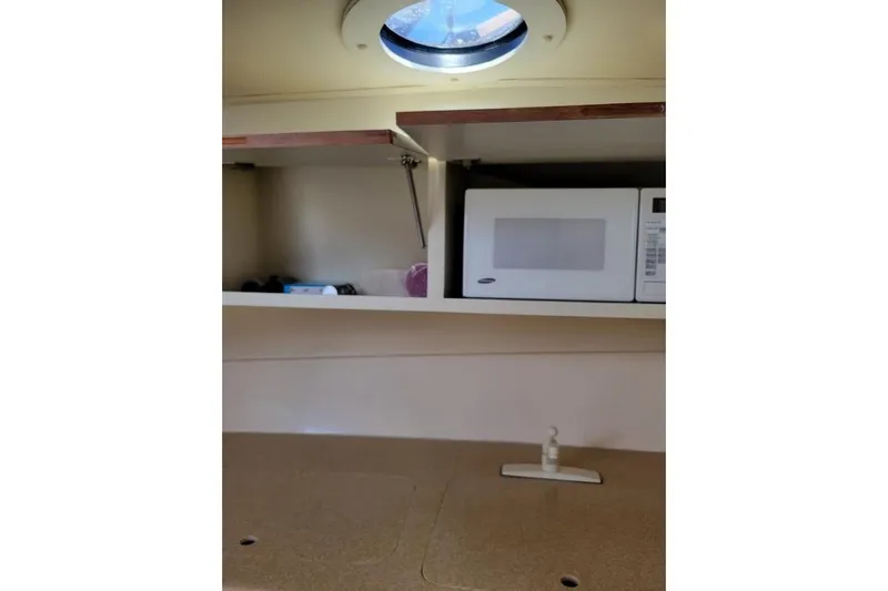 Slide: The Image of Interior of 1996 Phoenix 34 Tournament boat with microwave and storage. - 28