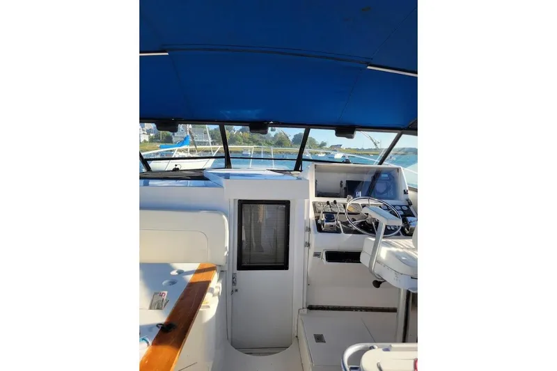 Slide: The Image of 1996 Phoenix 34 Tournament boat cockpit with blue canopy and steering wheel. - 3