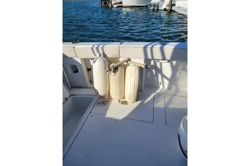 Slide: The Image of 1996 Phoenix 34 Tournament boat deck with fenders, docked on calm water. - 37