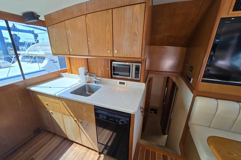 Slide: The Image of 1986 Ocean Yachts 55 Super Sport kitchen with wood cabinetry and modern appliances. - 22