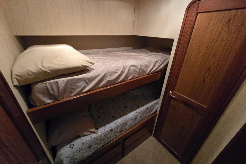 Slide: The Image of 1986 Ocean Yachts 55 Super Sport cabin with bunk beds and wooden door. - 27