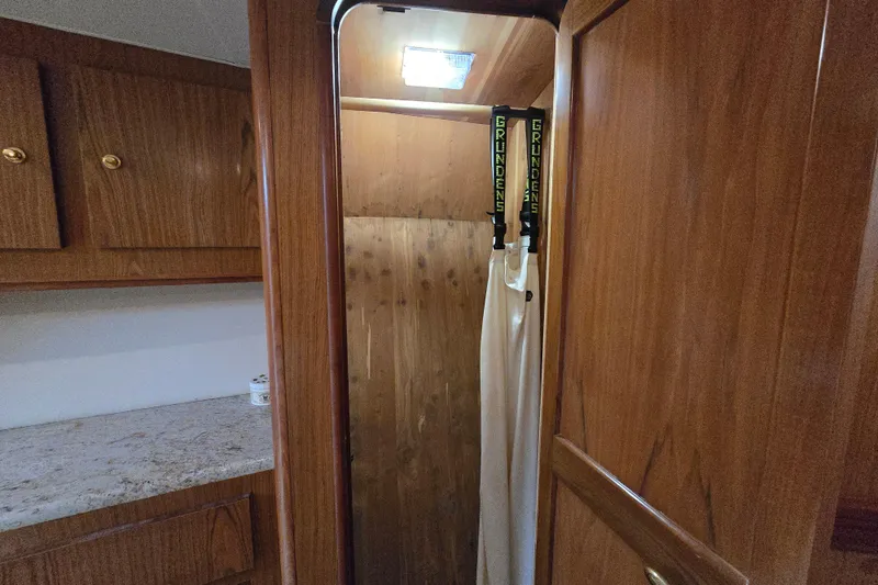Slide: The Image of 1986 Ocean Yachts 55 Super Sport interior with wooden cabinetry and hanging gear. - 33