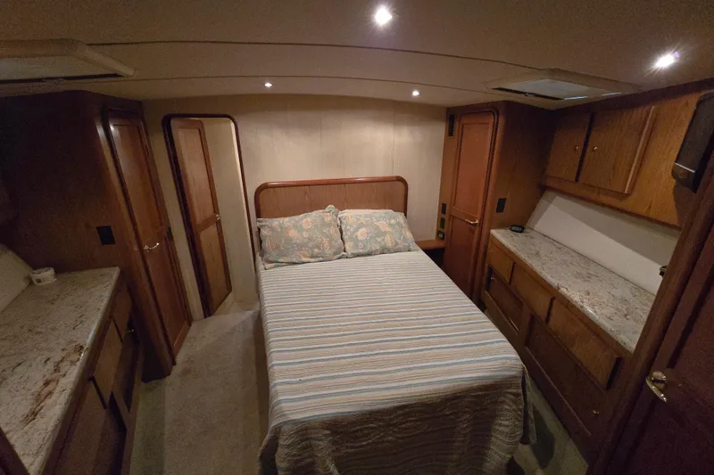 Slide: The Image of Luxurious bedroom interior of 1986 Ocean Yachts 55 Super Sport with cozy bed and wooden cabinetry. - 39