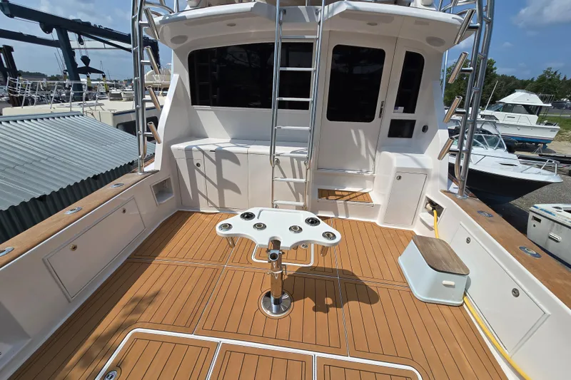 Slide: The Image of 1986 Ocean Yachts 55 Super Sport cockpit with teak flooring and fishing rod holders. - 49