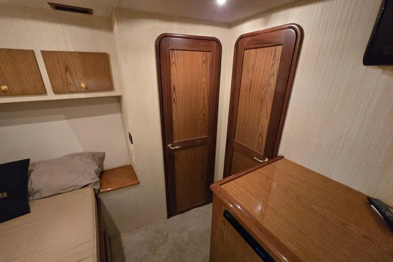 Slide: The Image of Interior of 1986 Ocean Yachts 55 Super Sport, featuring wooden doors and cozy cabin space. - 30