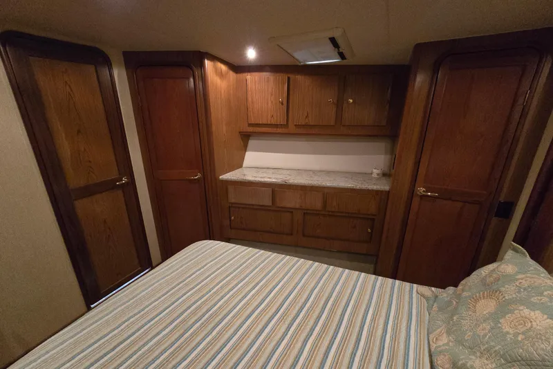 Slide: The Image of Interior cabin of 1986 Ocean Yachts 55 Super Sport with wooden cabinetry and striped bedding. - 35