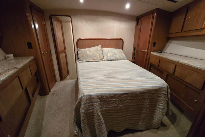 Slide: The Image of 1986 Ocean Yachts 55 Super Sport cabin with bed, wood cabinetry, and soft lighting. - 38