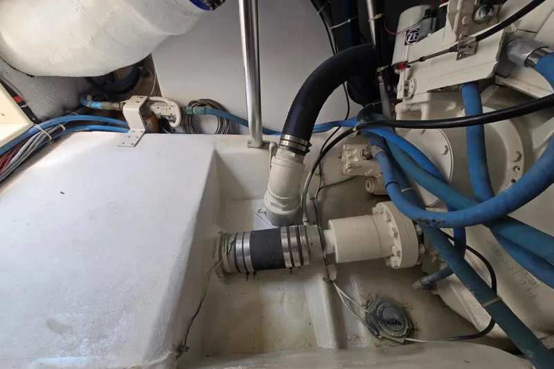 Slide: The Image of Engine room of 1986 Ocean Yachts 55 Super Sport with hoses and mechanical components. - 54