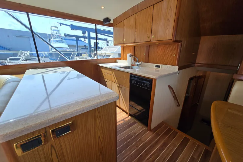 Slide: The Image of 1986 Ocean Yachts 55 Super Sport interior with wooden cabinetry and modern kitchen amenities. - 16