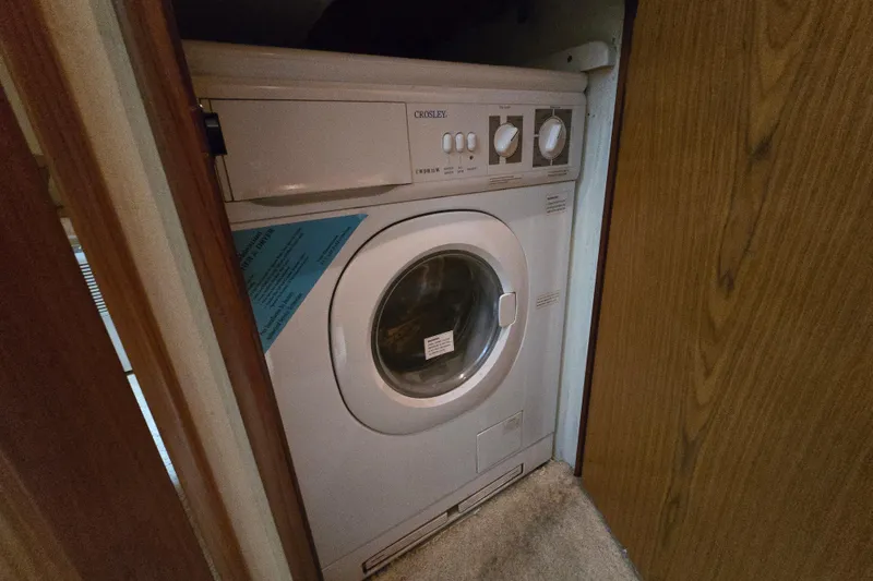 Slide: The Image of Washing machine inside 1986 Ocean Yachts 55 Super Sport, compact laundry area. - 28