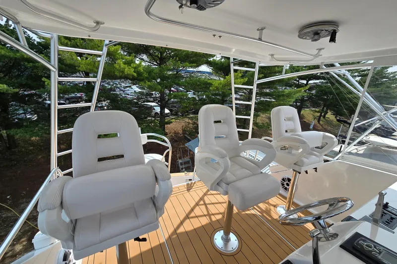 Slide: The Image of 1986 Ocean Yachts 55 Super Sport yacht helm with three white captain chairs. - 43