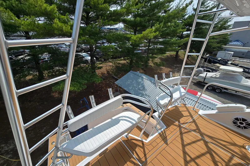 Slide: The Image of 1986 Ocean Yachts 55 Super Sport deck with seating and ladder, surrounded by trees. - 45